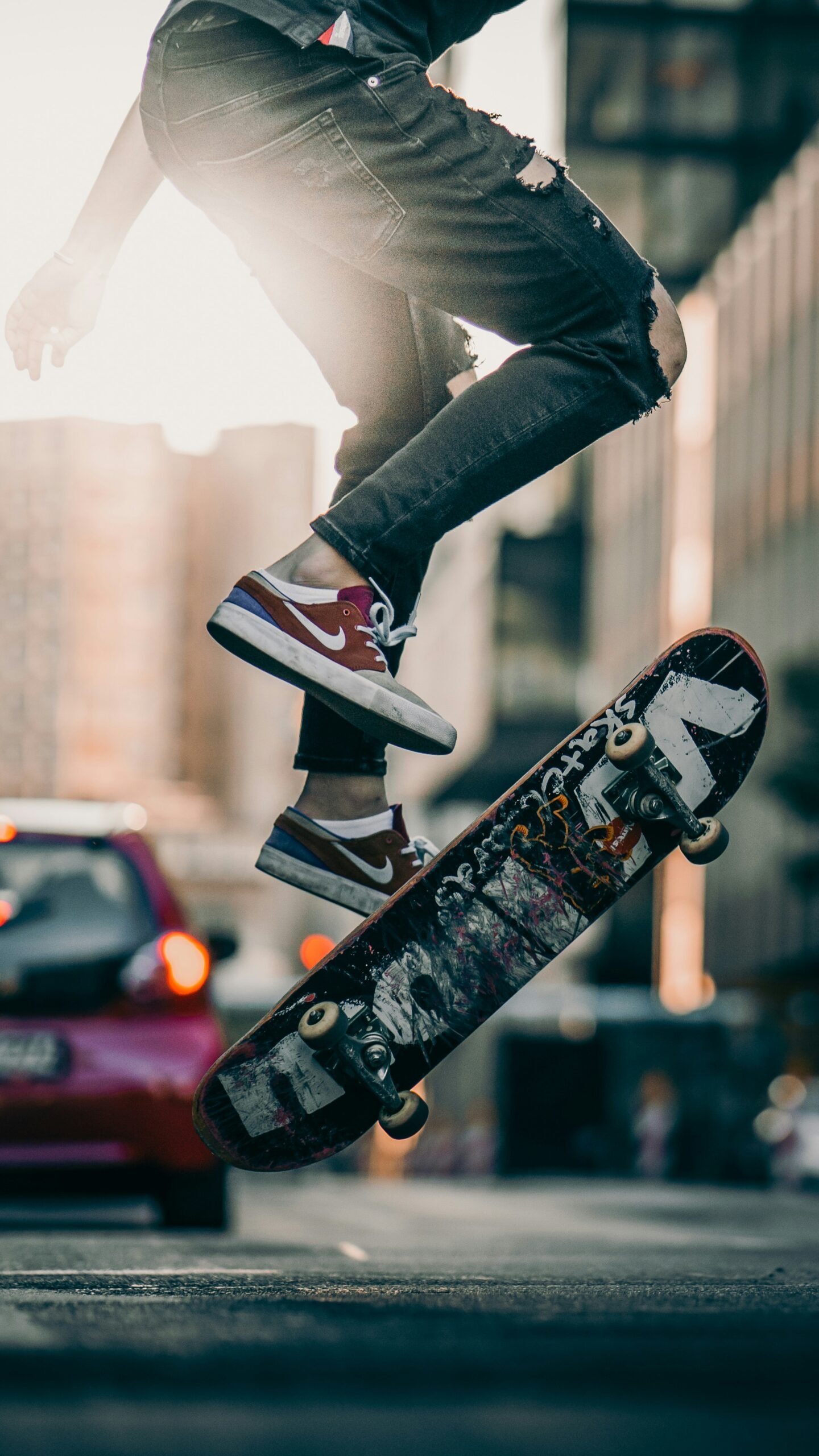 person in black pants and black and white sneakers jumping on skateboard