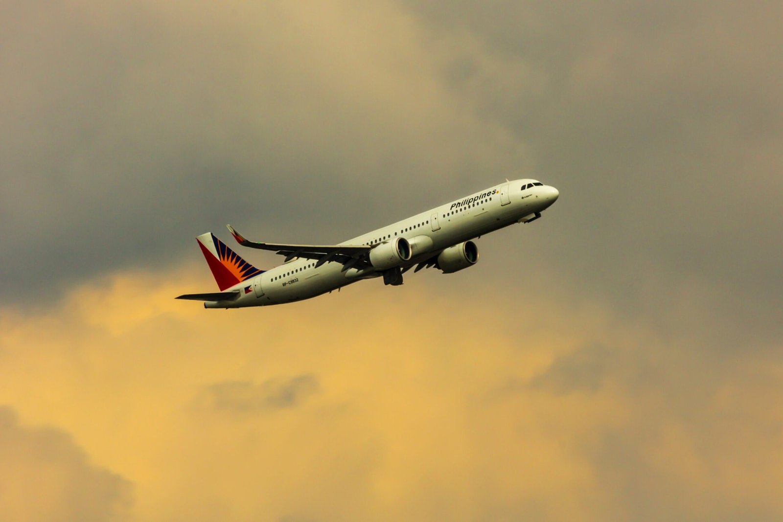 white and red air plane flying in the sky during daytime